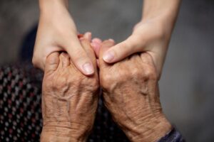 mani giovani afferrano mani anziane