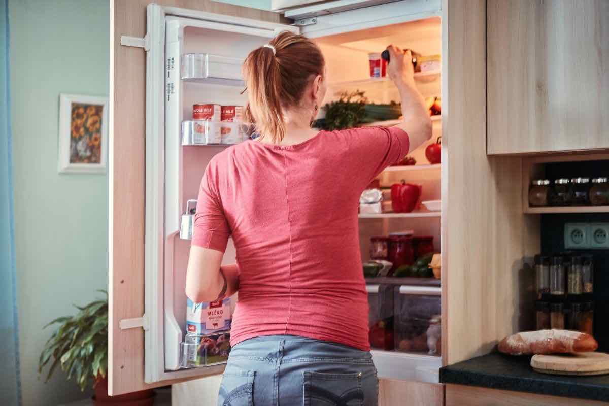 Donna davanti al frigorifero