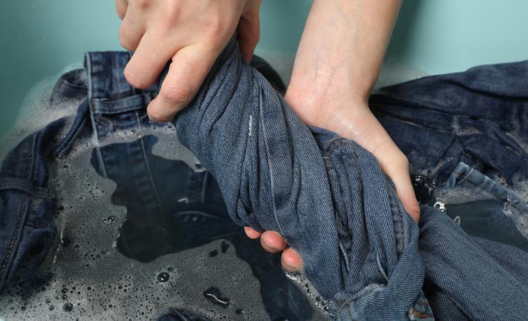 Persona che lava jeans a mano