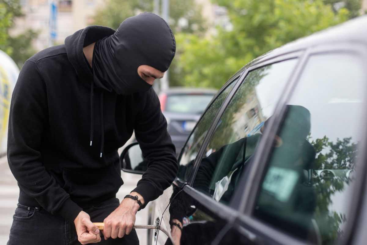 Ladro che prova ad aprire una macchina