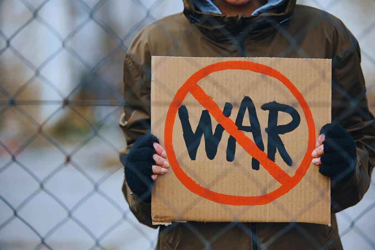 Persona che mostra un cartello contro la guerra 