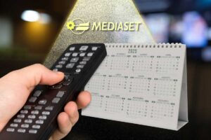 Mano con telecomando, calendario, logo Mediaset e fascio di luce