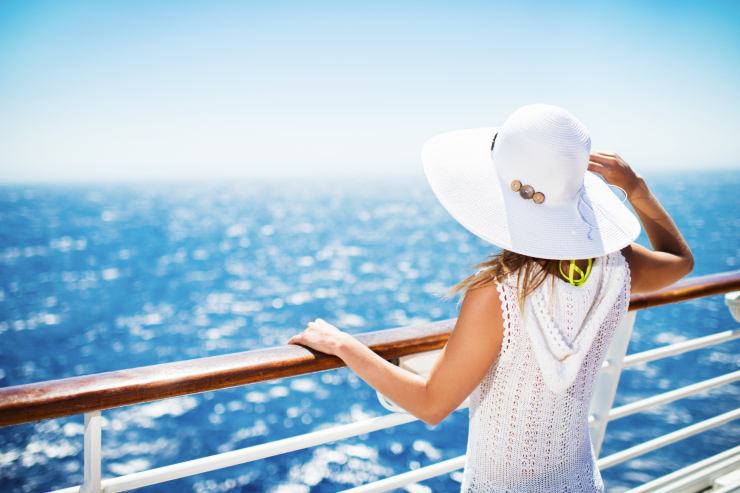 donna con cappello sulla nave di fronte al mare