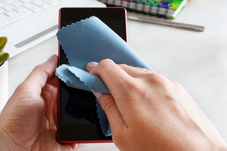 Pulire schermo cellulare con panno azzurro