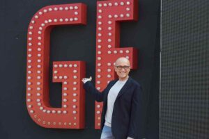 Alfonso Signorini vicino alla scritta GF in grande
