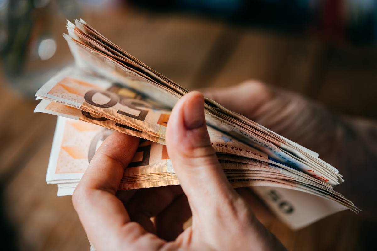 mani di donna contano mazzetta banconote da 50 euro