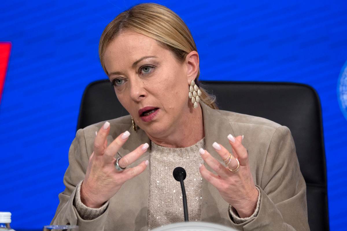 il premier giorgia meloni mentre parla al microfono e gesticola con le mani