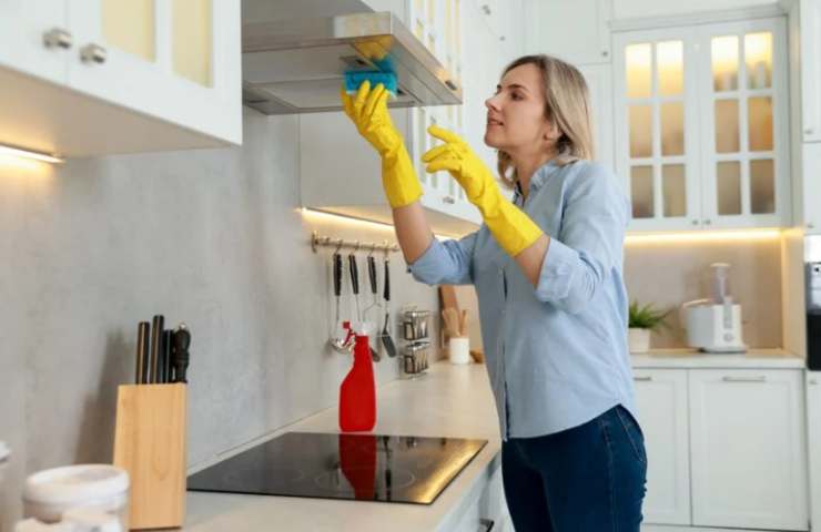 Donna pulisce la cappa della cucina